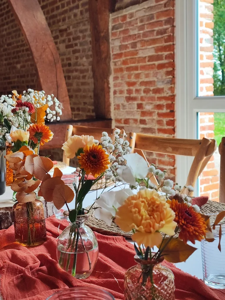 Centres de tables floraux automnaux dans une grange normande